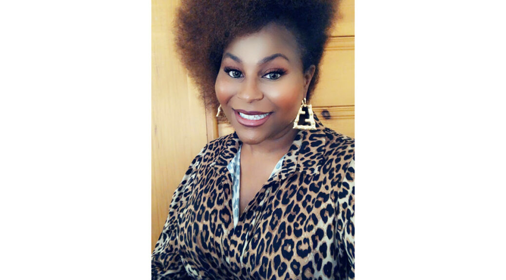 Breonna McCree, wearing a leopard-print blouse and smiling at the camera.